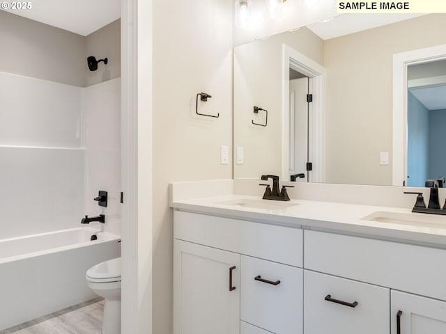 bathroom with a sink, toilet, double vanity, and shower / tub combination