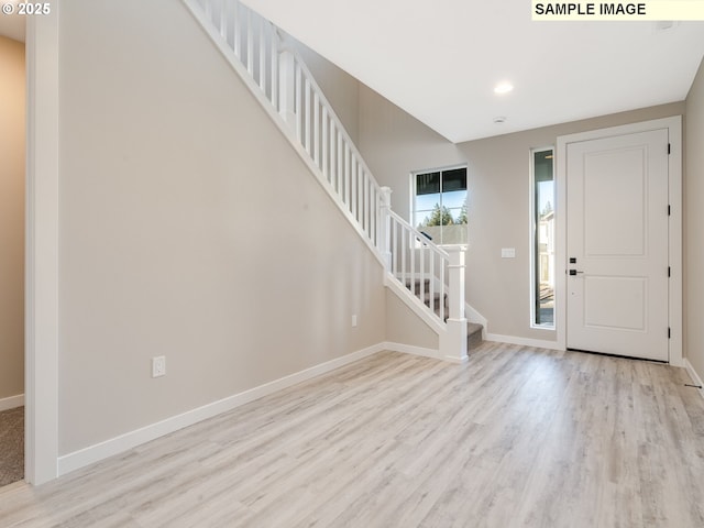 foyer entrance featuring stairway, recessed lighting, wood finished floors, and baseboards