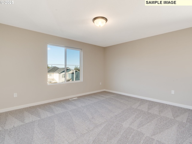 spare room with baseboards and carpet