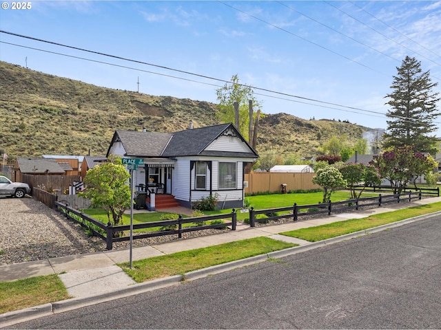 bungalow with a mountain view and a shingled roof