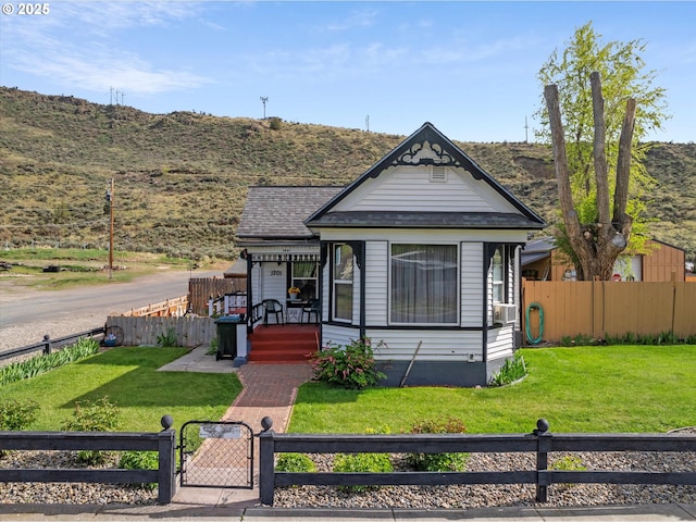 victorian-style house featuring a gate, a mountain view, covered porch, and cooling unit