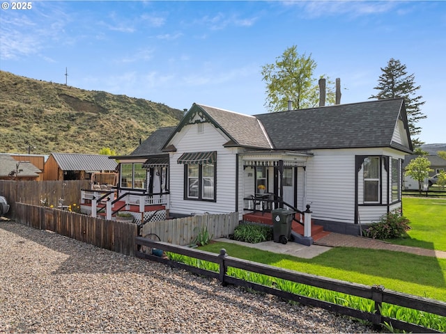 view of front of home with a shingled roof and a mountain view