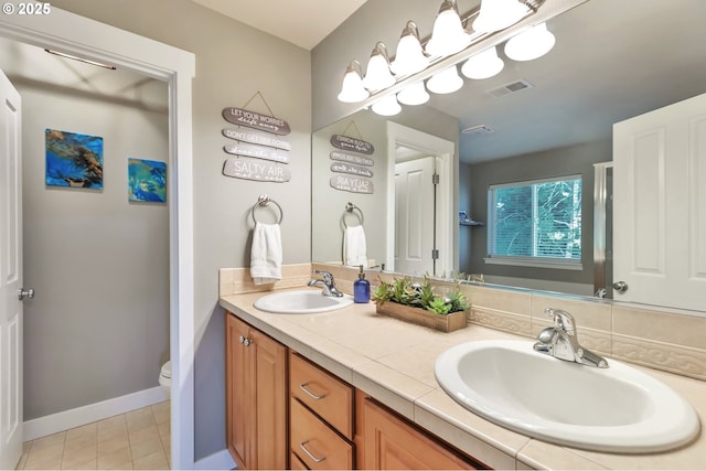 12130 SW Kelly Ln, Tigard, OR 97223 - full bathroom featuring toilet, double vanity, and baseboards