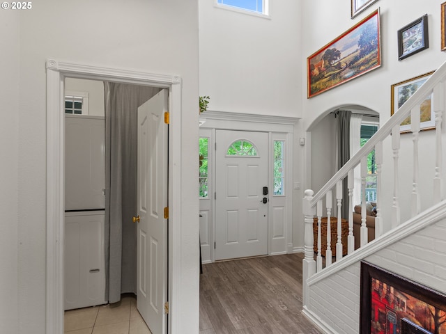 17717 NE 26th St, Vancouver, WA 98684 - entrance foyer with a high ceiling, arched walkways, stairs, stacked washing machine and dryer, and light wood-type flooring