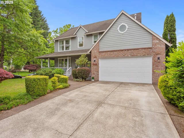 17717 NE 26th St, Vancouver, WA 98684 - view of front facade with brick siding, a porch, concrete driveway, roof with shingles, and an attached garage