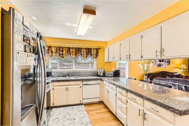 17180 NW Joscelyn St, Beaverton, OR 97006 - kitchen with white dishwasher, stainless steel fridge with ice dispenser, tile counters, a sink, and light wood finished floors