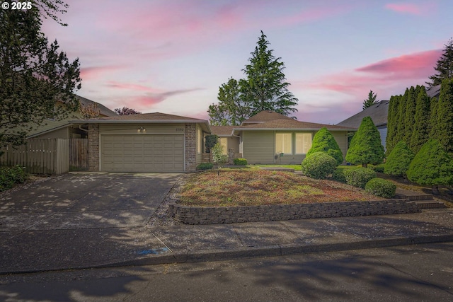 17180 NW Joscelyn St, Beaverton, OR 97006 - view of front of home featuring brick siding, an attached garage, driveway, and fence