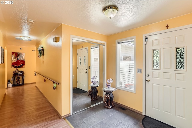 17180 NW Joscelyn St, Beaverton, OR 97006 - entryway featuring a textured ceiling, baseboards, and wood finished floors