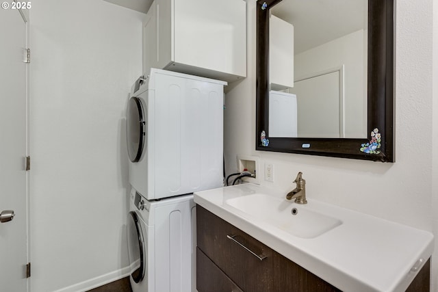 bathroom with stacked washer / drying machine and vanity