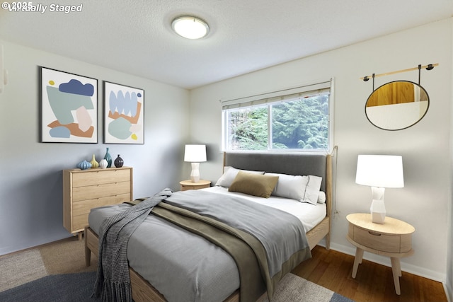 bedroom featuring hardwood / wood-style flooring and a textured ceiling