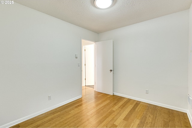 empty room featuring light hardwood / wood-style floors and a textured ceiling