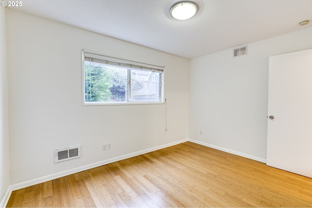 spare room with wood-type flooring and a textured ceiling