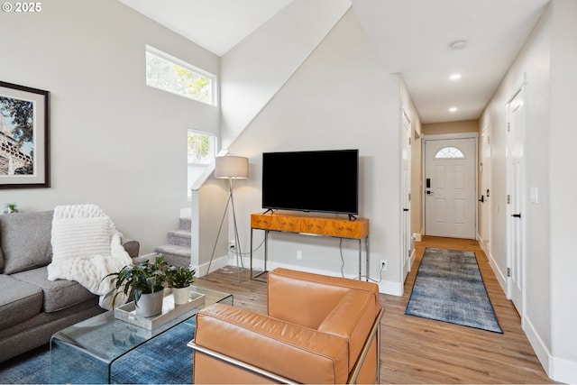 living room with stairway, recessed lighting, baseboards, and light wood-type flooring