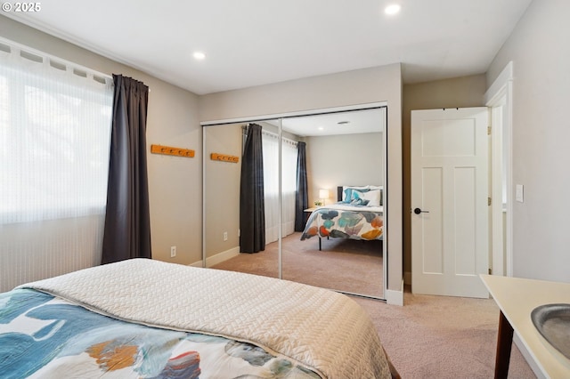 bedroom with recessed lighting, a closet, and light colored carpet