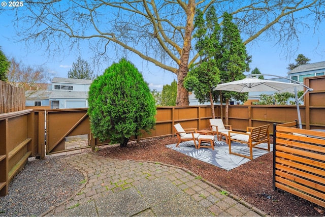 view of patio / terrace featuring an outdoor hangout area, a fenced backyard, and a gate