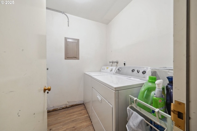 washroom featuring electric panel, laundry area, independent washer and dryer, and light wood-style flooring