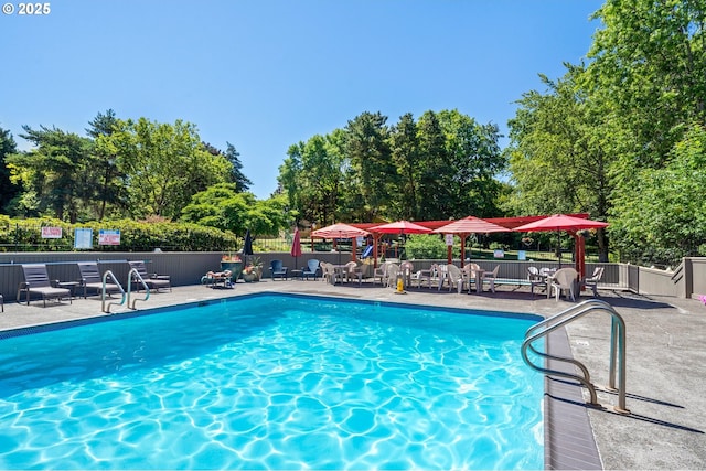 pool with a patio and fence