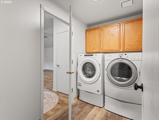 14108 NE 94th St, Vancouver, WA 98682 - washroom featuring washing machine and dryer, cabinet space, and light wood-type flooring