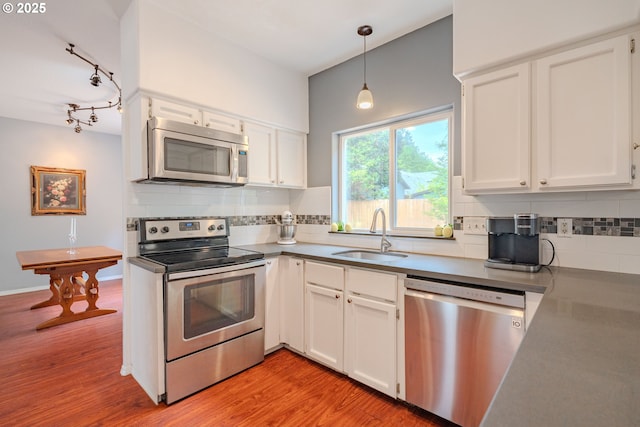 17474 SW Sarala St, Beaverton, OR 97007 - kitchen with stainless steel appliances, a sink, decorative backsplash, and white cabinetry