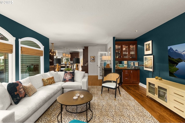 living area featuring wine cooler, baseboards, and dark wood-style flooring