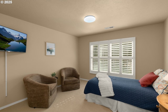 carpeted bedroom featuring visible vents, a textured ceiling, and baseboards