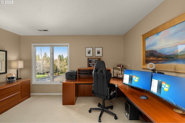 office area featuring visible vents, light colored carpet, and baseboards