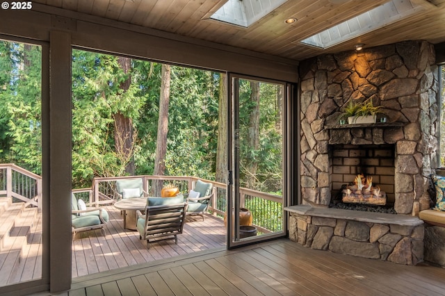 unfurnished sunroom featuring wooden ceiling, a skylight, and plenty of natural light