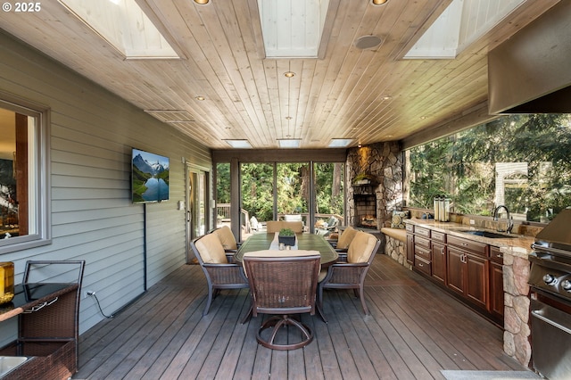 wooden deck featuring outdoor dining space, exterior kitchen, and a sink