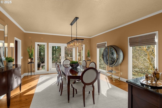 dining space featuring ornamental molding, baseboards, and wood finished floors