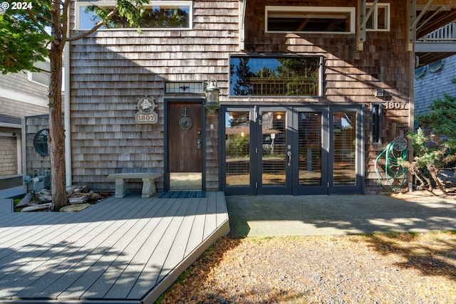 view of exterior entry featuring french doors and a deck