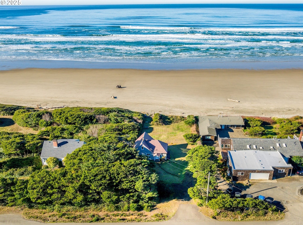 birds eye view of property with a water view and a beach view