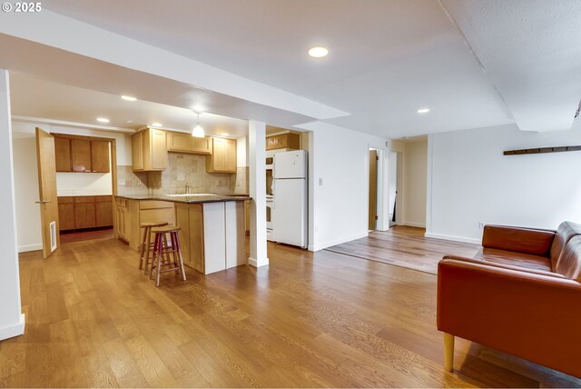 1917 SE 51st Ave, Portland, OR 97215 - kitchen with freestanding refrigerator, open floor plan, decorative backsplash, and light wood-style floors