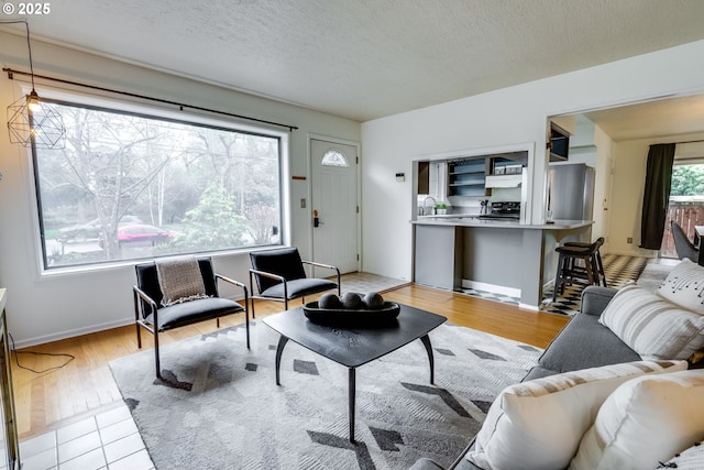 1917 SE 51st Ave, Portland, OR 97215 - living room with a textured ceiling, baseboards, and light wood-style floors