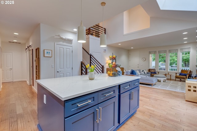 kitchen with light wood-style flooring, open floor plan, hanging light fixtures, recessed lighting, and a center island