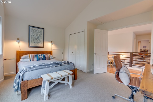 carpeted bedroom with baseboards, a closet, and vaulted ceiling