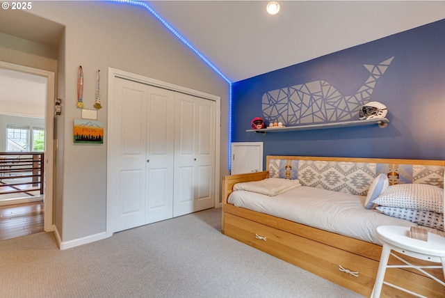bedroom featuring vaulted ceiling, carpet flooring, a closet, and baseboards