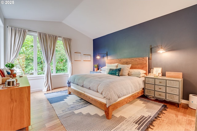 bedroom with lofted ceiling, wood finished floors, and baseboards