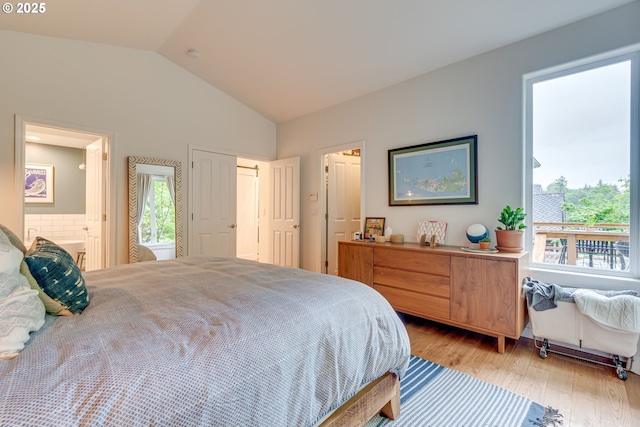 bedroom with lofted ceiling, light wood-style flooring, and ensuite bathroom