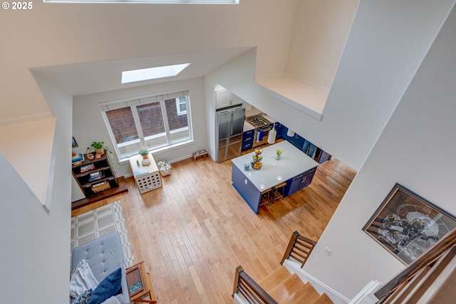 living room featuring a skylight and light wood-style floors