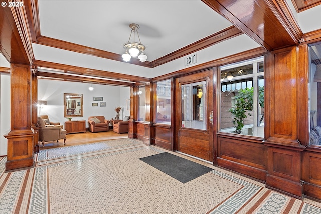 foyer with ornamental molding and a chandelier