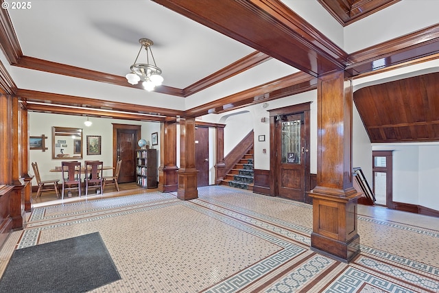 entryway with ornamental molding, a chandelier, and ornate columns