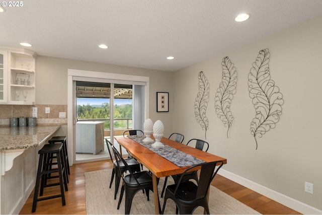 dining space with recessed lighting, light wood-style flooring, and baseboards