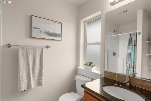 bathroom featuring toilet, visible vents, curtained shower, and vanity