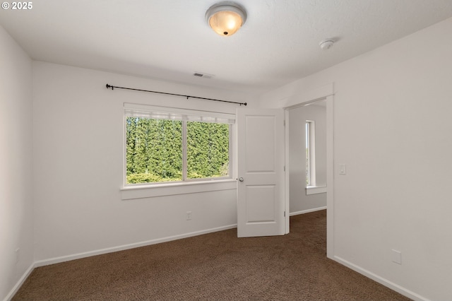 unfurnished bedroom with carpet flooring, baseboards, and visible vents