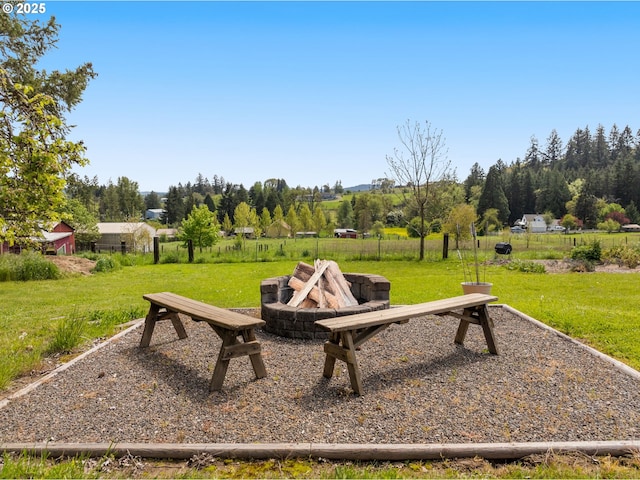 view of property's community featuring a lawn and an outdoor fire pit