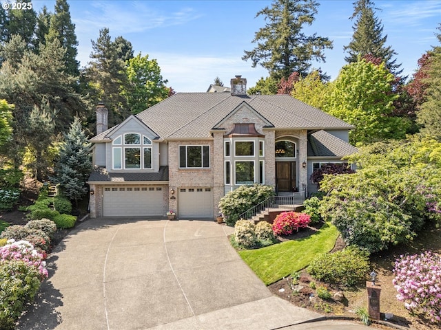 craftsman inspired home featuring brick siding, driveway, a chimney, and a garage