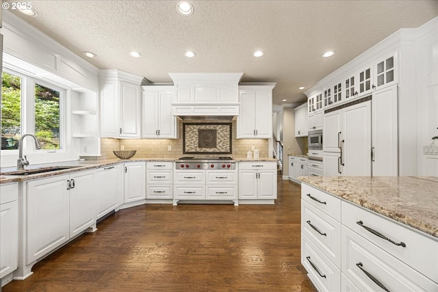kitchen with recessed lighting, white cabinets, a sink, dark wood finished floors, and backsplash
