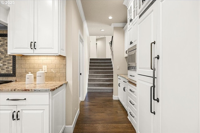interior space featuring recessed lighting, baseboards, ornamental molding, and dark wood finished floors