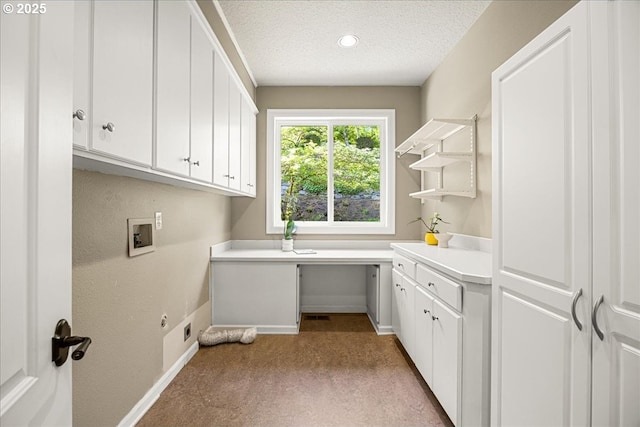 washroom with cabinet space, washer hookup, a textured ceiling, baseboards, and electric dryer hookup