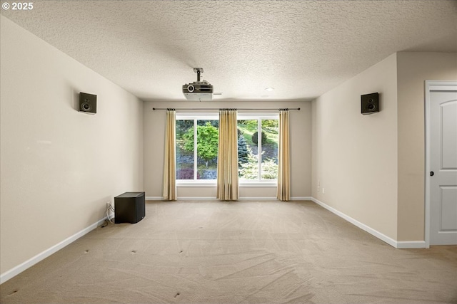 carpeted empty room with a textured ceiling and baseboards